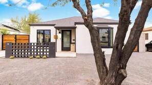 Une maison moderne à deux étages, dotée d’un garage, d’une porte d’entrée et d’un petit porche.
