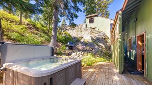 A hot tub on a wooden deck with a view of a mountain and a cabin. - Trapper Cabin in Alpine Meadows w/ hot tub (Alpine Meadows)