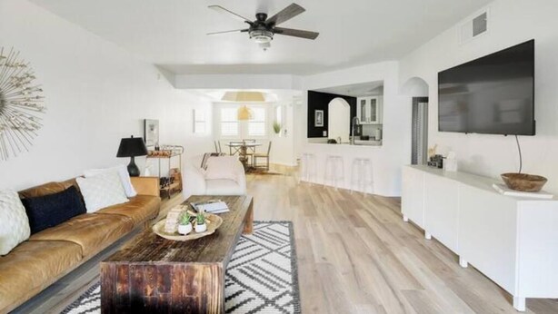 A modern living room with a sofa, coffee table, and a TV mounted on the wall.