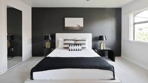 A modern bedroom with a large bed, a ceiling fan, and a window providing natural light. - Escape 48! Heated Pool, Hot Tub, Fitness Center, walk to Coffee, Grocery (Phoenix)