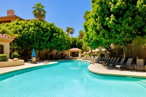 A swimming pool with lounge chairs and umbrellas, surrounded by trees and buildings. - Escape 48! Heated Pool, Hot Tub, Fitness Center, walk to Coffee, Grocery (Phoenix)