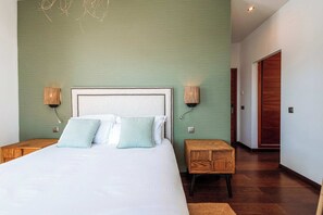 Une chambre à coucher avec un grand lit, deux tables de chevet et une armoire en bois.