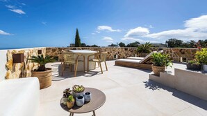 A rooftop terrace with a stone wall, a round table with chairs, and potted plants. - Poolside Room - Deluxe Boutique B&B Ojén/Marbella (Ojén)