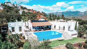 A modern villa with a swimming pool, surrounded by lush greenery and a mountainous backdrop. - Poolside Room - Deluxe Boutique B&B Ojén/Marbella (Ojén)