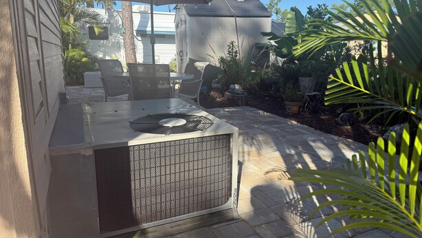 An outdoor patio with a grill, umbrella, and seating area. - Turtle cove: Perfect Cozy Oasis in SWFL with Pool, Hot Tub & More! (Fort Myers)
