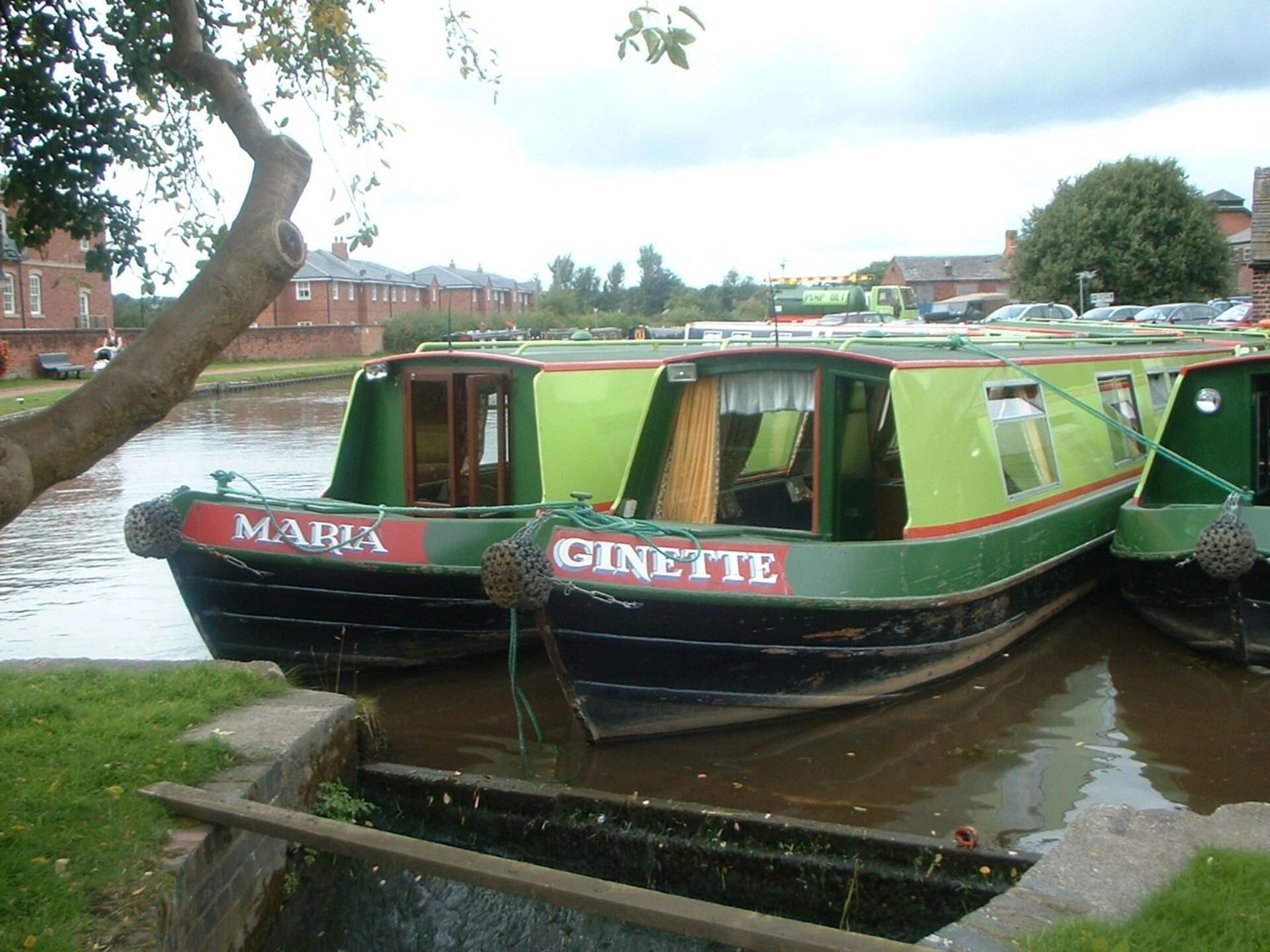 Two narrowboats named 'Maria' and 'Ginette' docked at a canal.