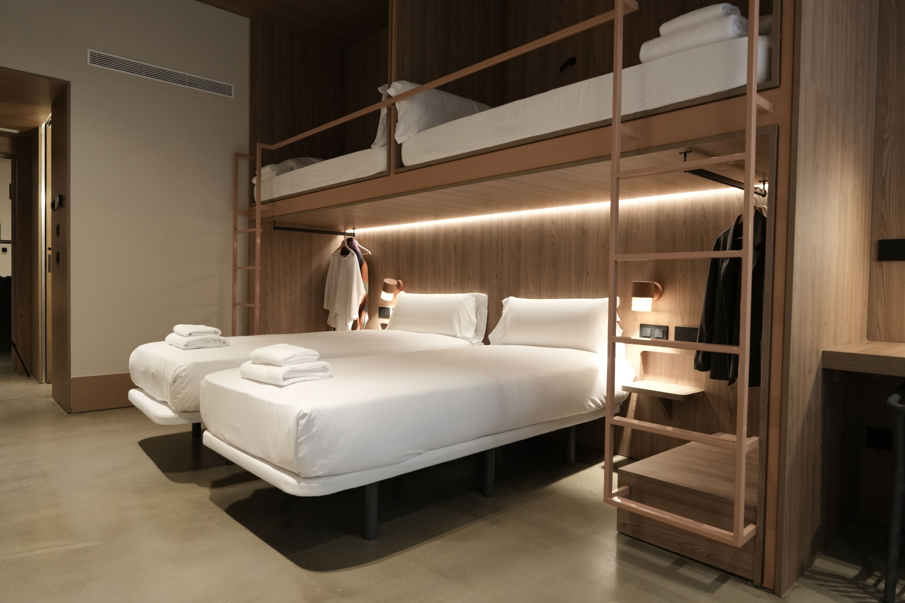 Habitación con literas, decoración de madera, escritorio y armario.