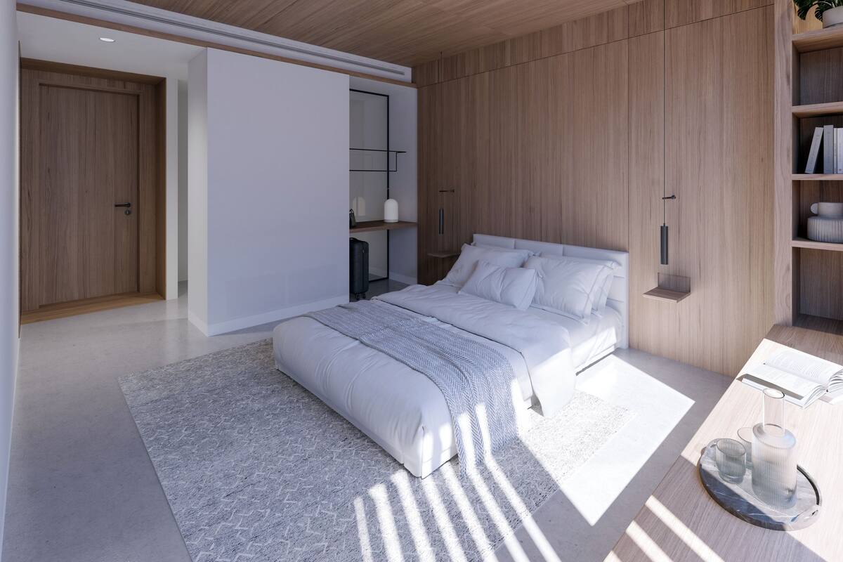 A modern bedroom with a large bed, a bedside table with a lamp, and a built-in wardrobe.