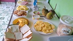 Una mesa con diversos alimentos, como pan, frutas y salsas.
