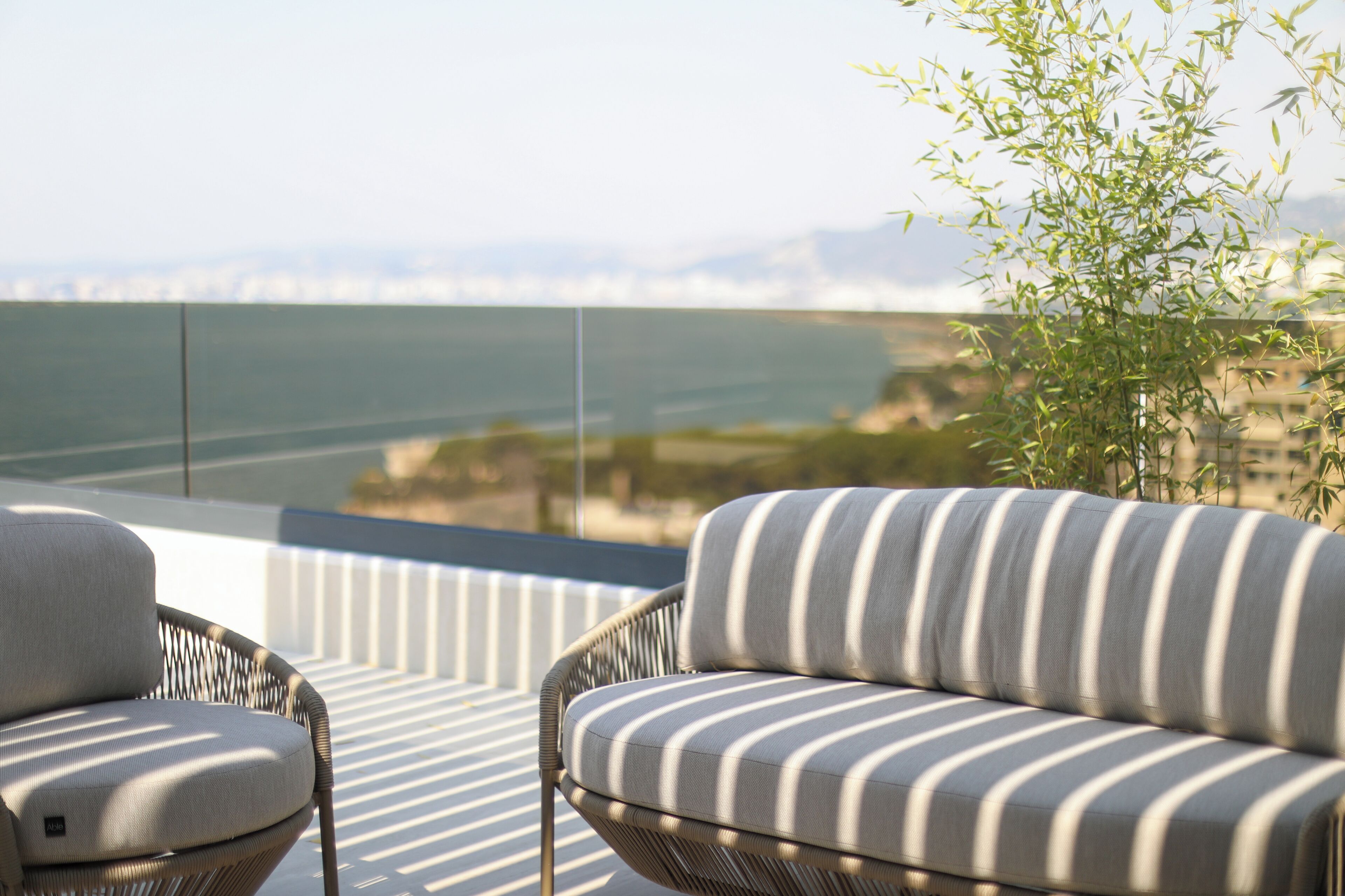A balcony with wicker furniture and a view of the sea.