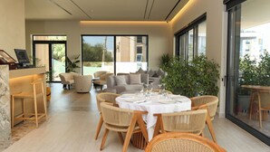 Un espace repas moderne avec une table ronde pour six personnes, entourée de chaises en osier.
