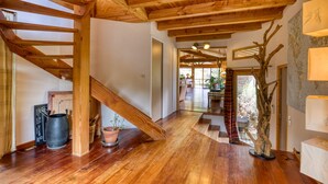 A spacious interior with wooden beams, a staircase, and a large tree sculpture. - Family Villa in Exceptional Setting with Mountain View, Wi-Fi, and Air Conditioning (Mourèze)