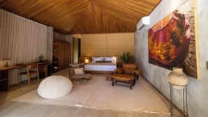 Un dormitorio amplio con una cama grande, techo de madera y un cuadro grande en la pared.