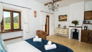 Una camera da letto con un letto, una poltrona, un camino e vista sull'esterno.