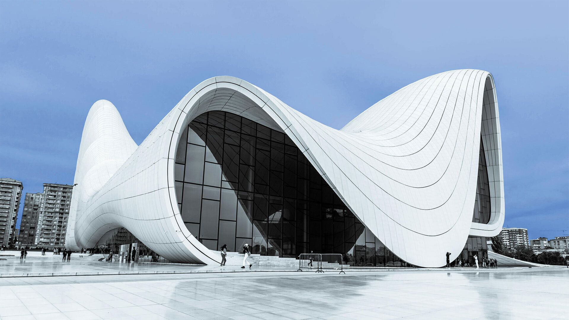 A modern architectural building with a curved facade and large glass windows.