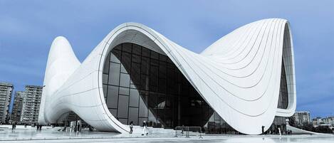 A modern architectural building with a curved facade and large glass windows.