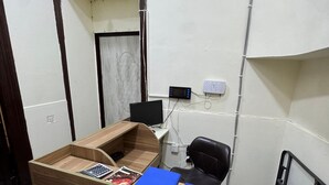 A small office with a desk, chair, computer, and a mirror. - Gulf Hostel (Baku)