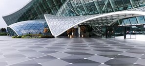 A modern building with a glass facade and a geometric entrance canopy. - Gulf Hostel (Baku)