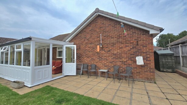 A brick house with a conservatory, a patio with chairs, and a small garden area. - Herne Bay - House - Sleeps 7 - Parking (Herne Bay)