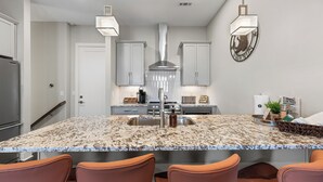 A modern kitchen with granite countertops, stainless steel appliances, and a central island with seating.