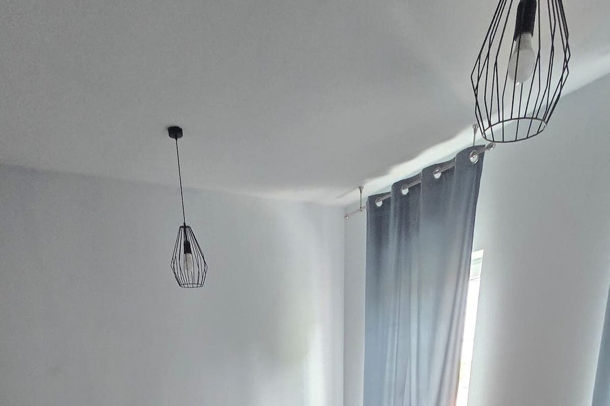 Un dormitorio con dos camas, un escritorio y una lámpara colgante.