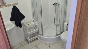A bathroom with a glass-enclosed shower, a white sink, and a toilet. - Średzka Korona (Środa Śląska)