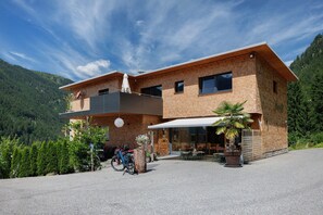 Ein modernes, zweistöckiges Gebäude mit Flachdach, großen Fenstern und einem Balkon.
