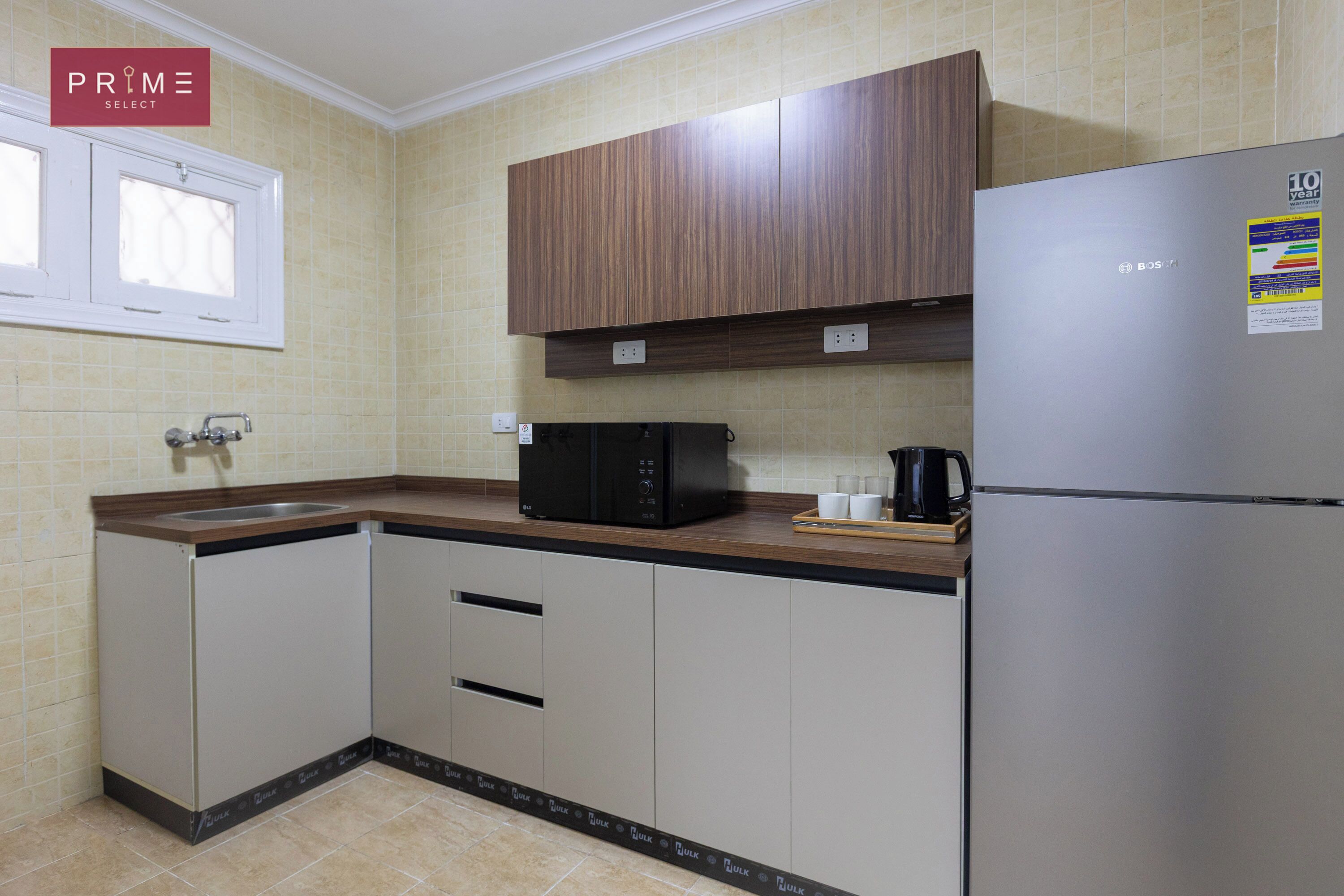 A kitchen with a stainless steel refrigerator, a microwave, and a coffee maker on the counter.