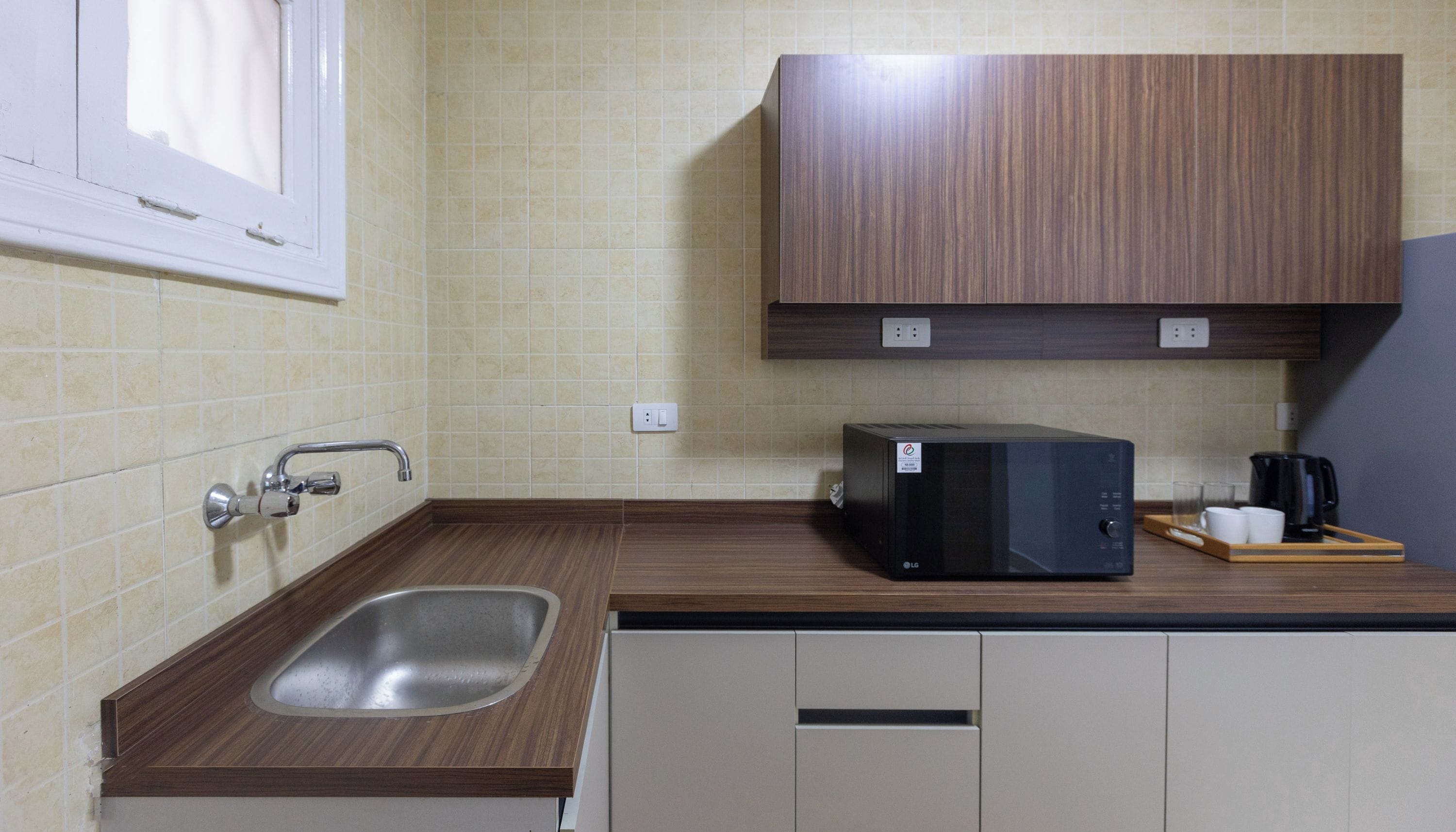 A kitchen with a sink, a microwave, and cabinets.