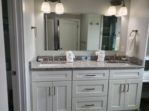 Un bagno con doppio lavabo, due portasciugamani e un grande specchio.