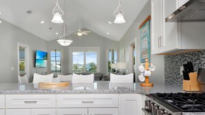 A modern kitchen with granite countertops, white cabinetry, and stainless steel appliances.