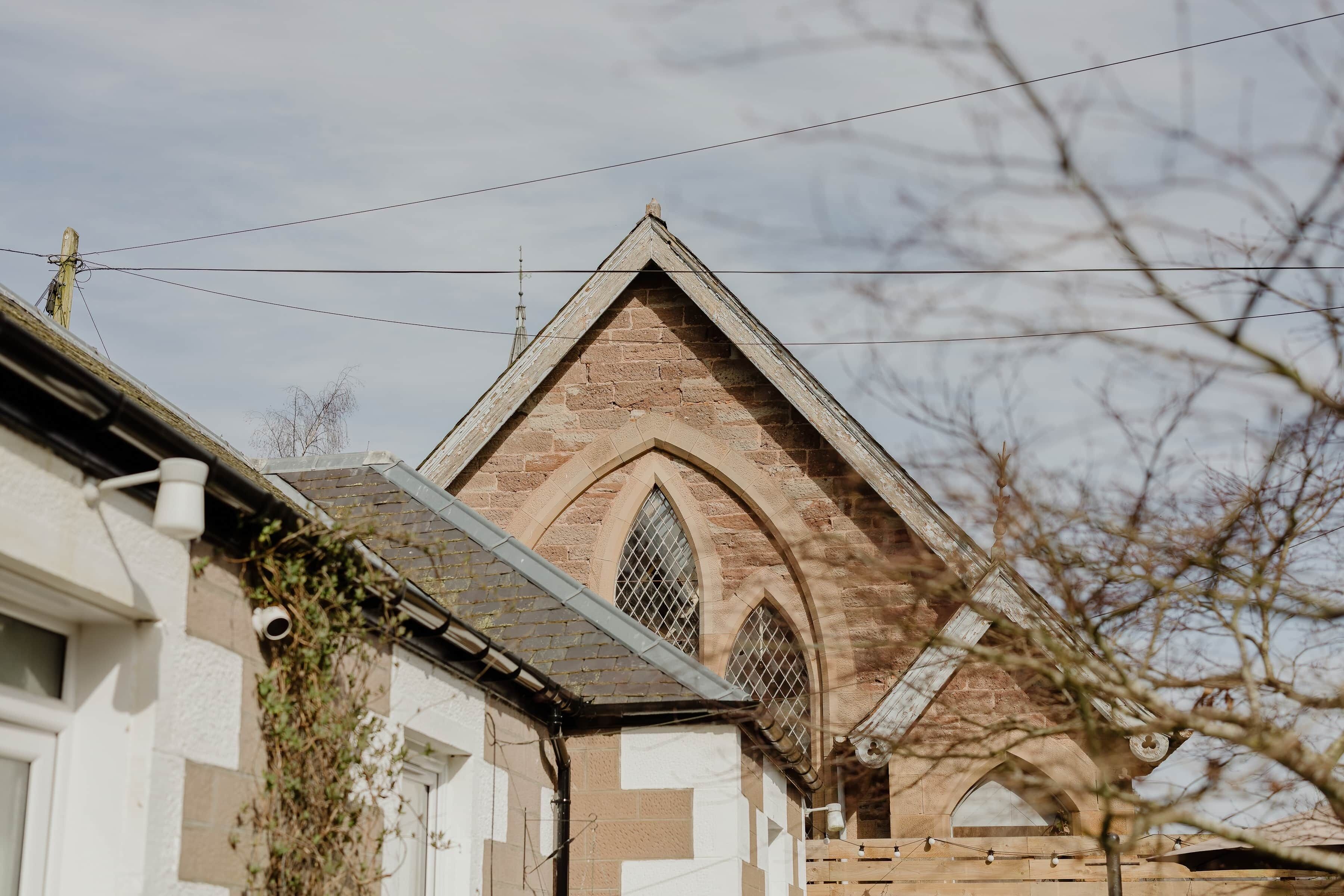 A building with a pointed roof, arched windows, and a brick facade.
