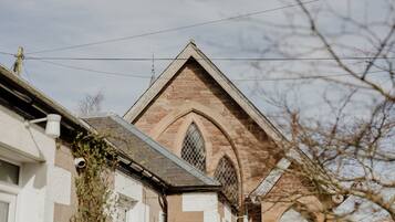 A building with a pointed roof, arched windows, and a brick facade.