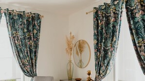 Een slaapkamer met een bed, een stoel, een kaptafel en gordijnen.