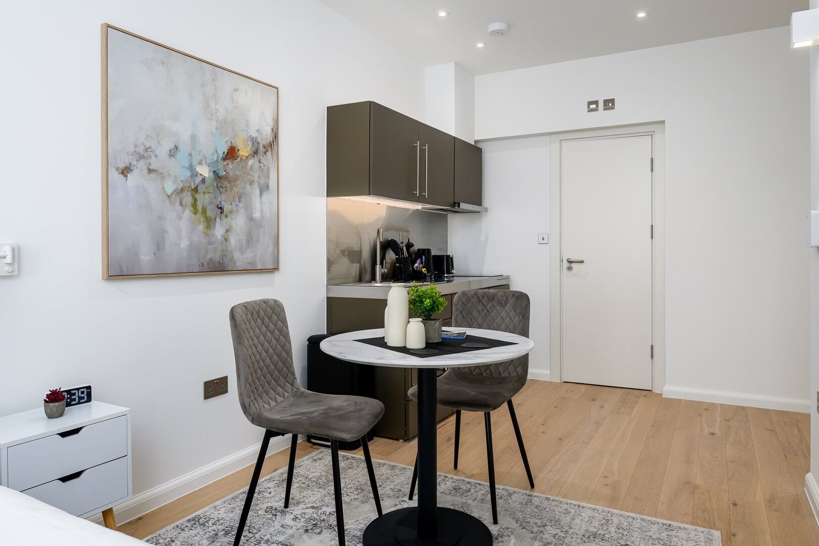 A modern kitchen with dark cabinets, a white countertop, and a built-in stove.