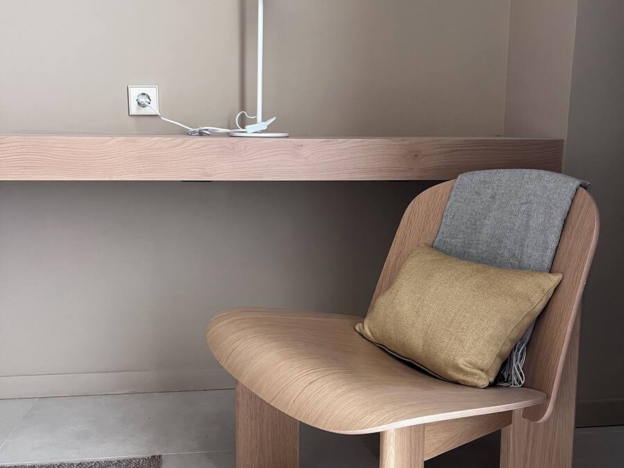 A modern chair with a cushion and a desk lamp.