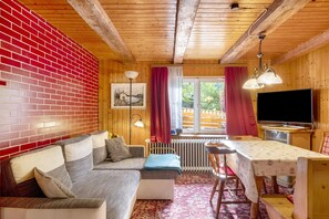 Un intérieur en bois avec un canapé, une table et un téléviseur.