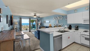 A kitchen with a large island, white cabinets, and a view of the ocean. - ☀️Beach Front-Free Beach Service-Pool + Hot Tub-Pelican Isle 107⛱️ (Ft. Walton Beach)