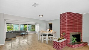 A spacious living room with a fireplace, a dining area, and a sofa.