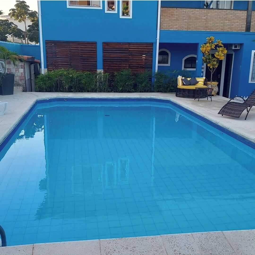 Una piscina rectangular con bordes de azulejos, rodeada por una plataforma de hormigón.