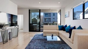 A modern living room with a sofa, coffee table, and TV.