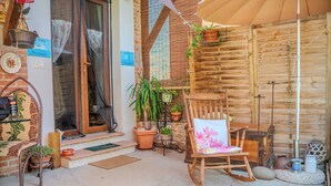 A wooden exterior with a wooden chair and potted plants. - Casa di Cristina - Tra Montepulciano e il Lago Trasimeno (Casamaggiore)
