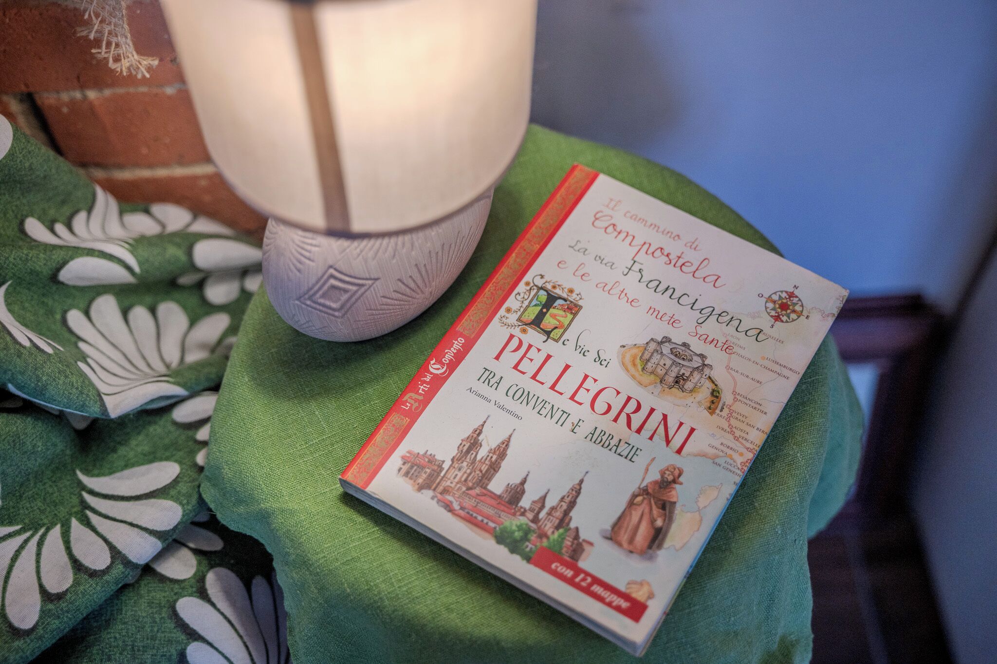 Um livro com o título 'Componno di PELLEGRINI' sobre um tecido verde.