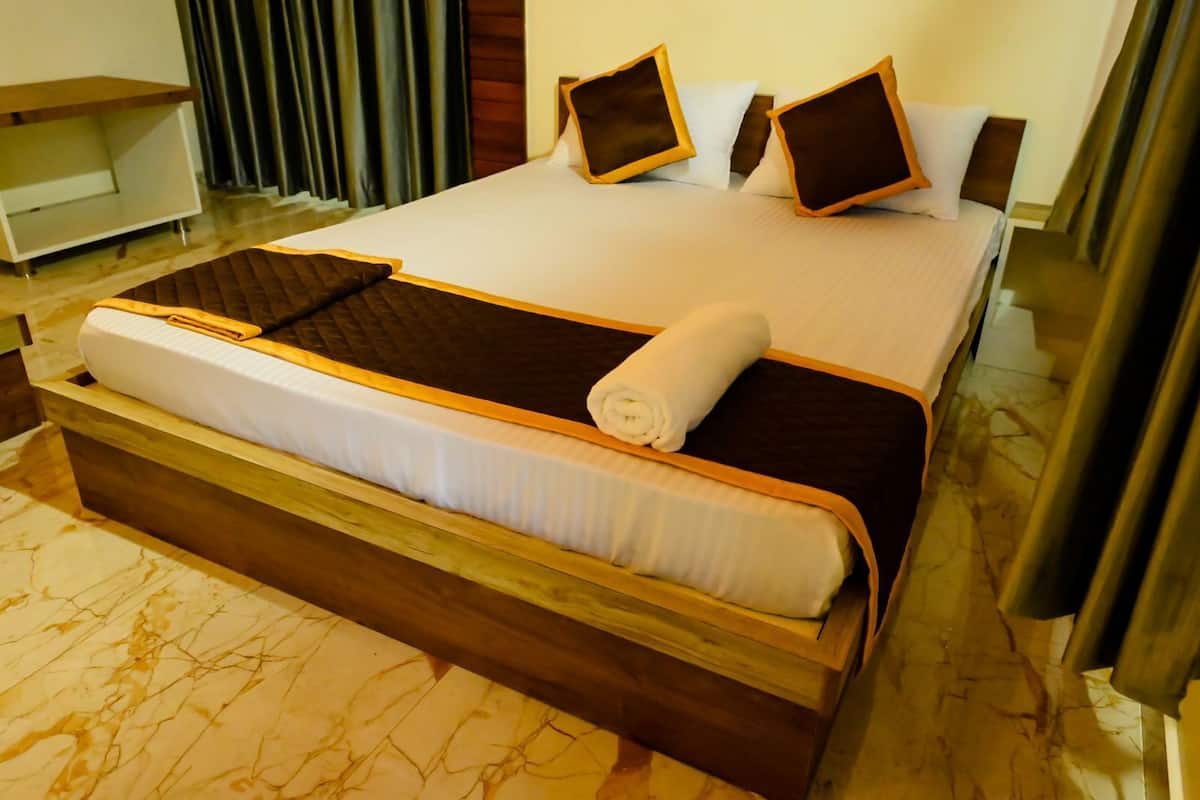 Ein Hotelzimmer mit einem großen Bett, einem Holzkopfende und einem Marmorboden.