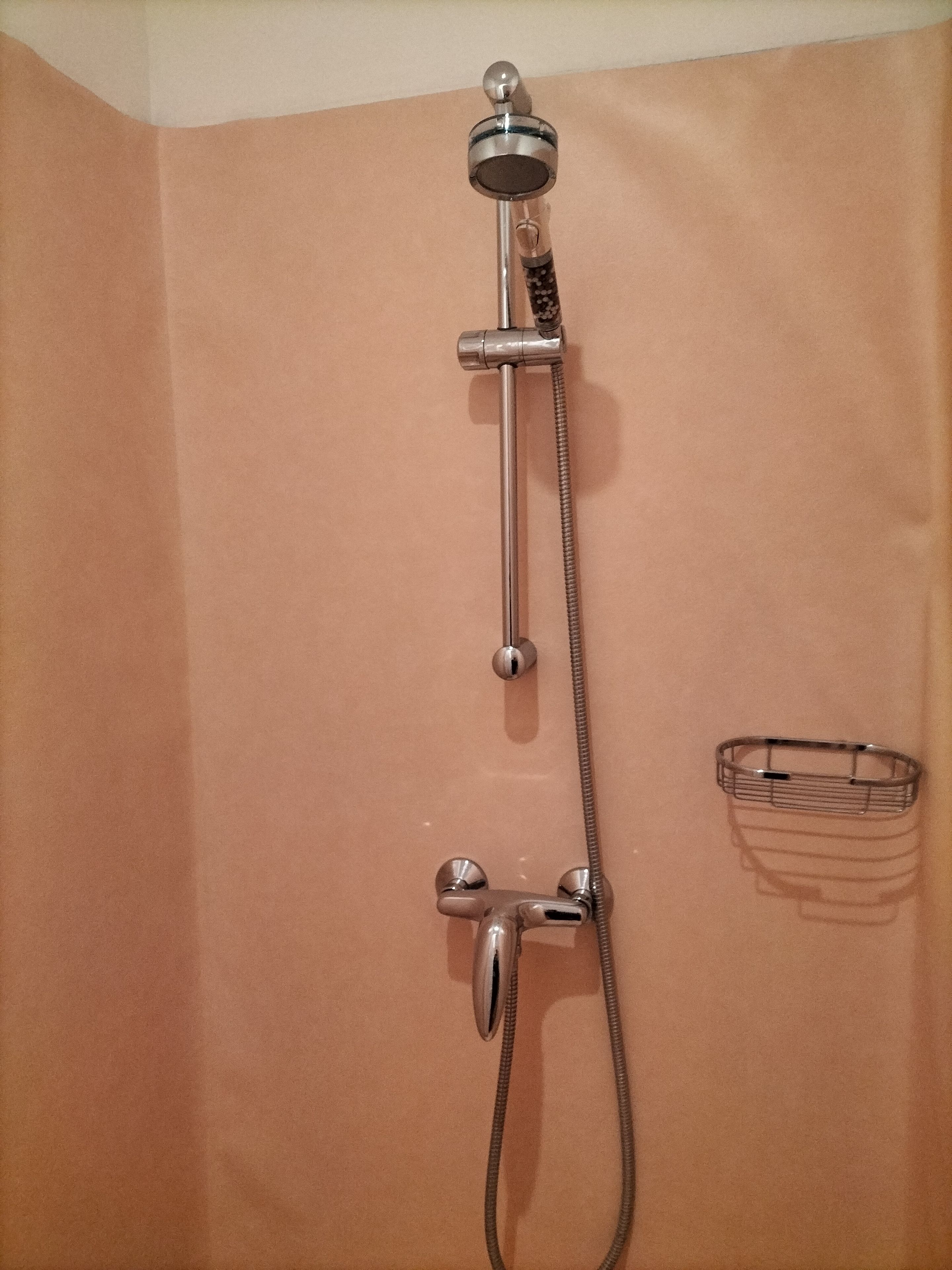 Een douche met een handdouche en een slang.