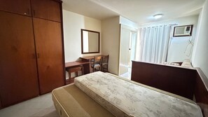 A bedroom with a bed, a desk, a chair, and a wardrobe. - Eldorado Flat (Caldas Novas)