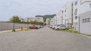 Une rue pavée bordée de voitures garées et d’immeubles modernes.