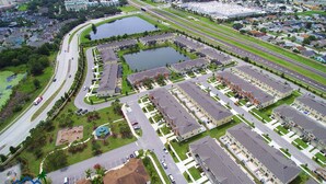 Luchtbeeld van een woongebied met meerdere appartementencomplexen, wegen en een groot waterlichaam.