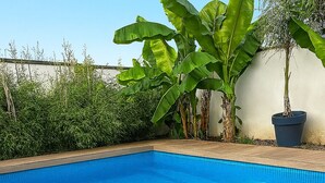 Ein rechteckiger Pool mit einer umlaufenden Holzterrasse.
