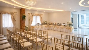 A banquet hall with rows of chairs, a buffet table, and a chandelier. - Bhadrachalam Nest Inn (Mysore)